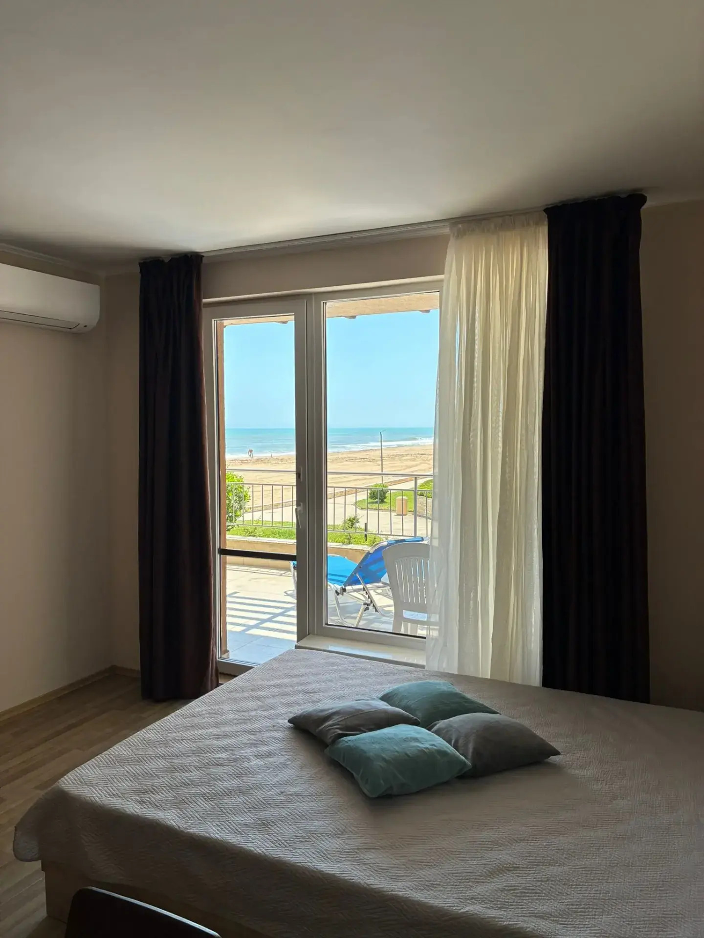 Ložnice s otevřenými dveřmi na balkon, výhled na moře, lehátka. v apartmánu Obzor