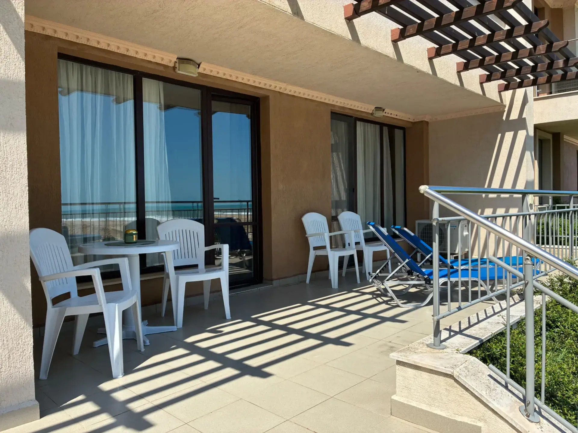 Slunná terasa u bytu s lehátky v apartmánu Obzor Beach Resort.